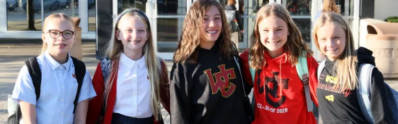 A photo of a group of smiling school girls wearing Worthington Christian-branded clothing.